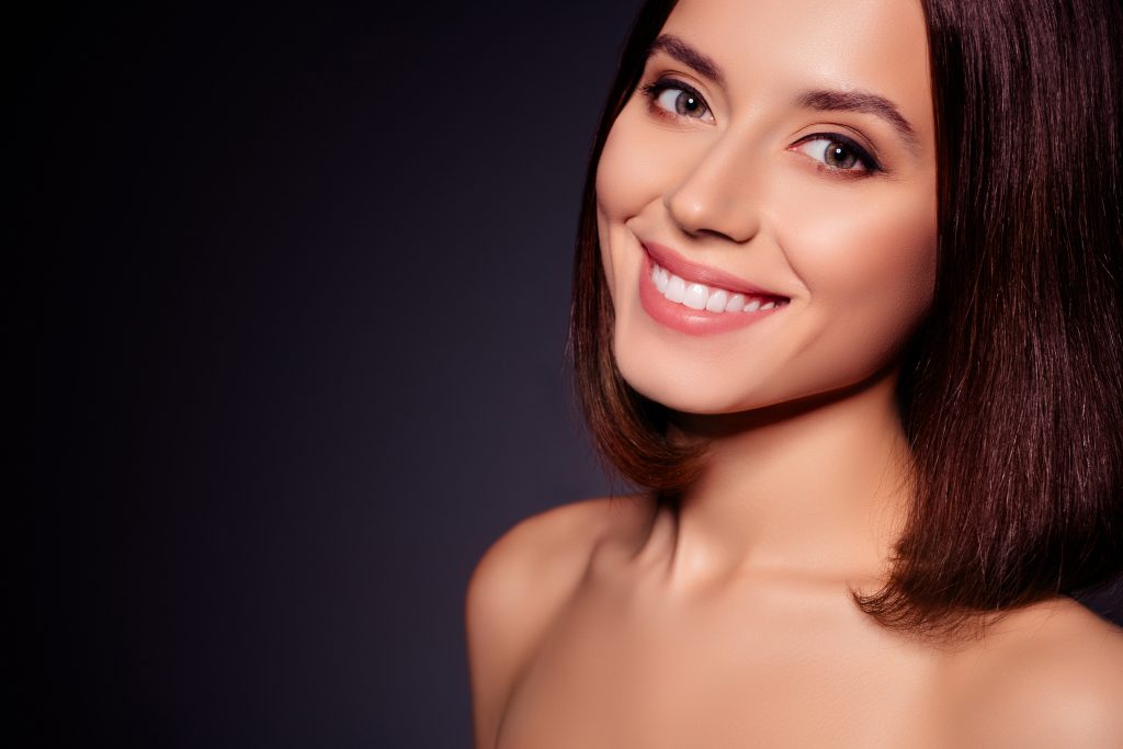 young woman with attractive smile against a black background, dental veneers, teeth whitening